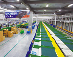 株式会社タカラトミー殿　1日当たり35万ピースを処理するピースソータ。シュート数は300（150×2ライン）で店舗別に商品を仕分ける。